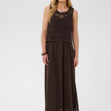 Woman wearing a brown dress with a crochet top on a white background