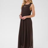 Woman wearing a brown dress with crochet detailing on a white background
