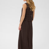 Woman wearing a brown dress with crochet detailing on a white background