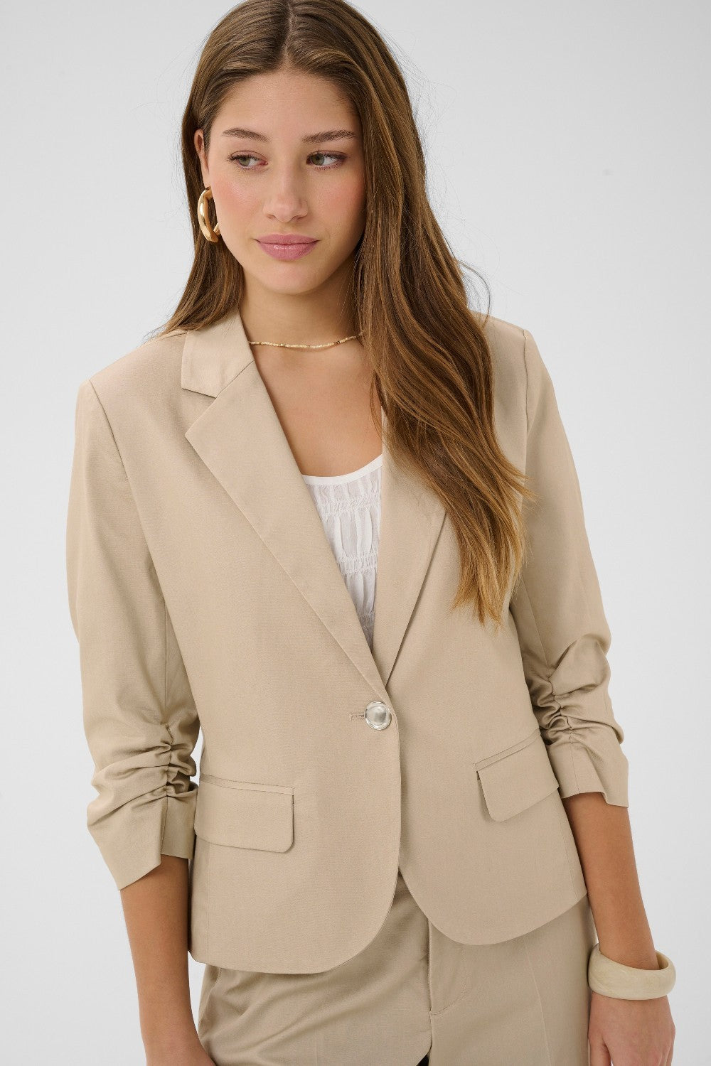 Effortless sophistication meets warm-weather style with the Cream Gia Short Blazer. This lightweight layer features a tailored silhouette that transitions seamlessly from office to weekend brunch.