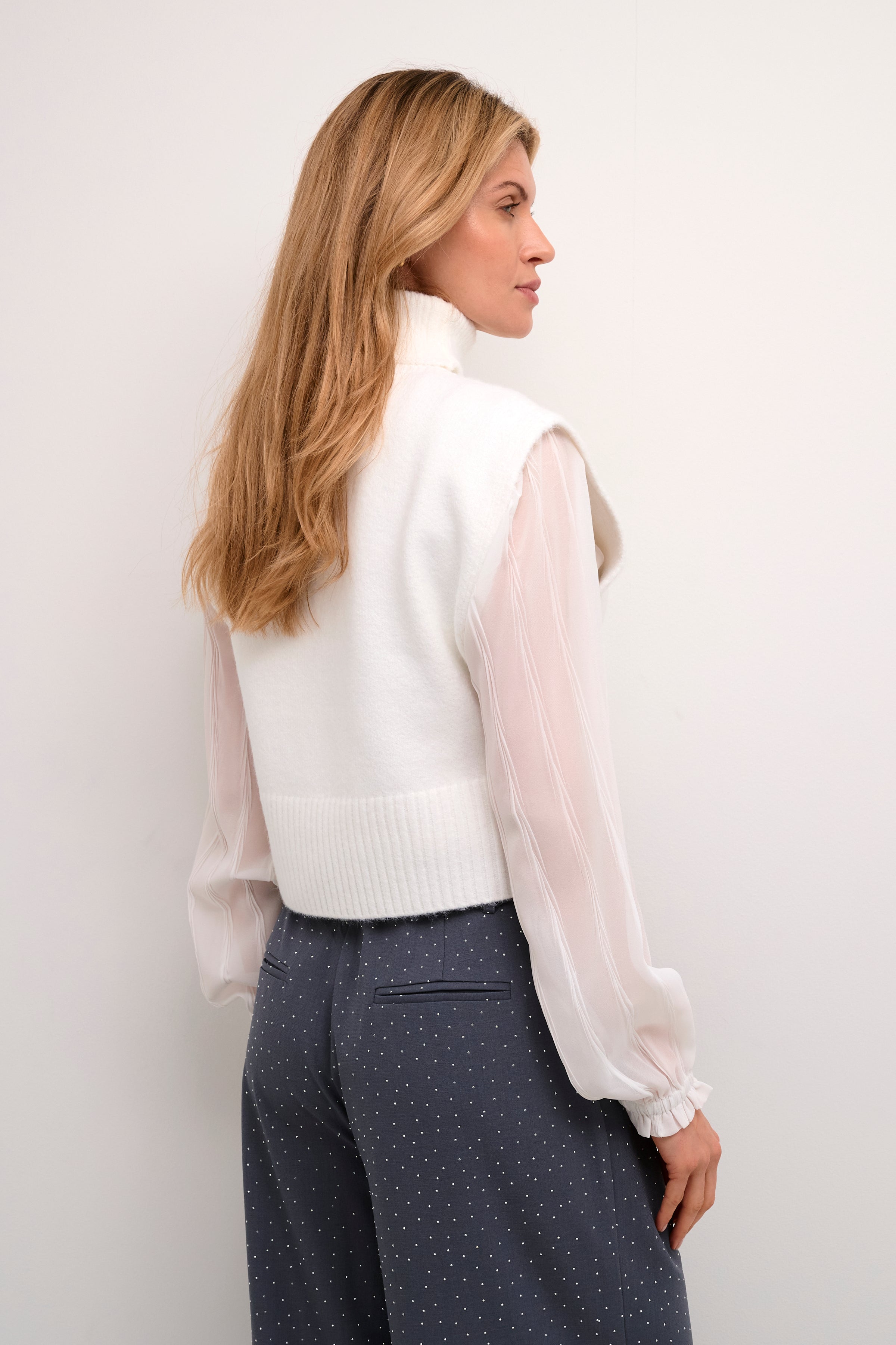 This Cream Ginger Knit Slipover adds a stylish layer to any outfit. The striking design and soft material make it a versatile choice for any occasion. With beautiful side buttons, it's both functional and fashionable. Elevate your wardrobe with this must-have piece.