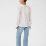 Person wearing a white shirt and light blue jeans on a white background