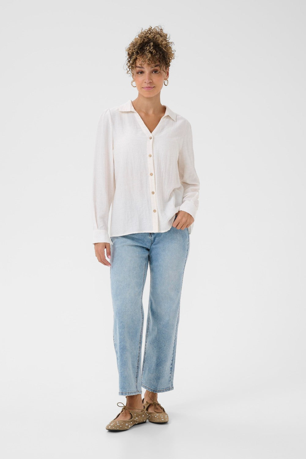 Person wearing a white shirt and light blue jeans on a white background