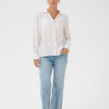Person wearing a white shirt and light blue jeans on a white background