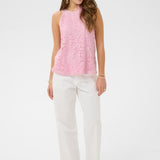 Woman wearing a pink sleeveless top and white pants on a white background