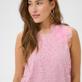Woman wearing a pink lace dress with floral details on a white background
