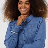 Woman wearing a blue blouse with a white background