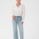 Woman wearing a white shirt and light blue jeans on a white background
