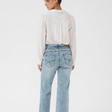 Person wearing light blue jeans and a white shirt on a white background