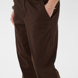 Brown pants worn by a person on a white background