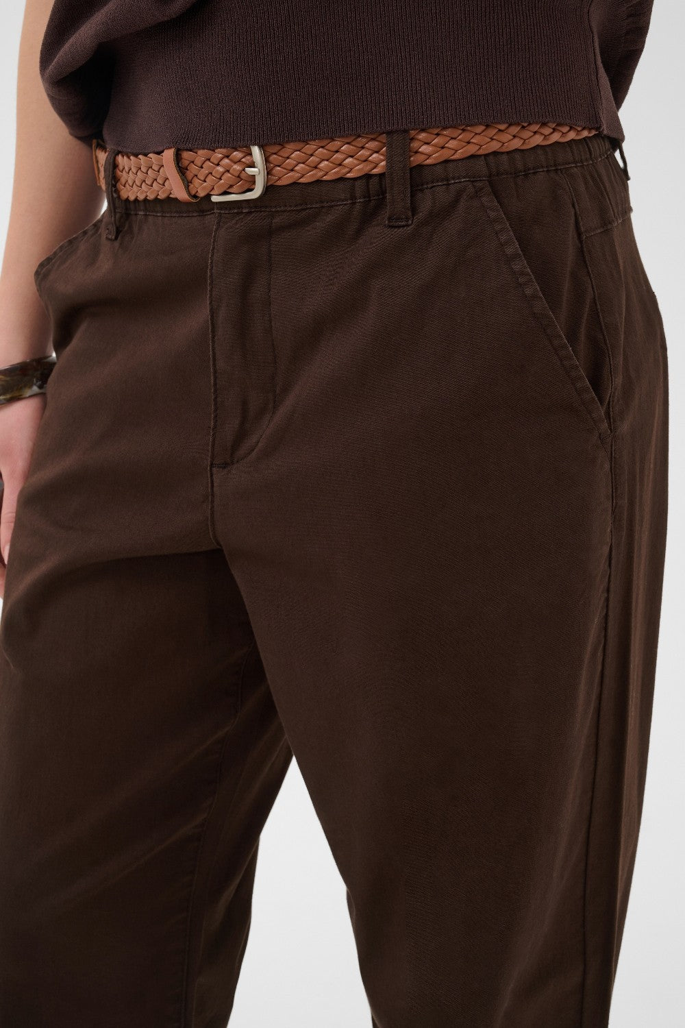 Brown pants with a woven belt on a white background