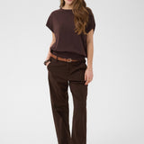 Woman wearing a brown outfit with a belt on a white background