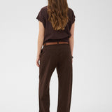 Person wearing a brown outfit with a belt on a white background