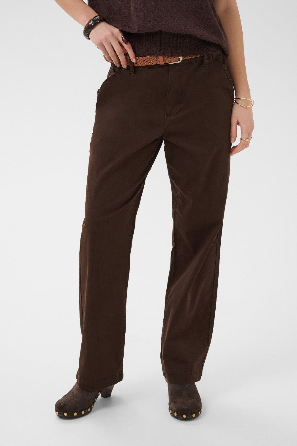 Brown pants worn by a person on a white background