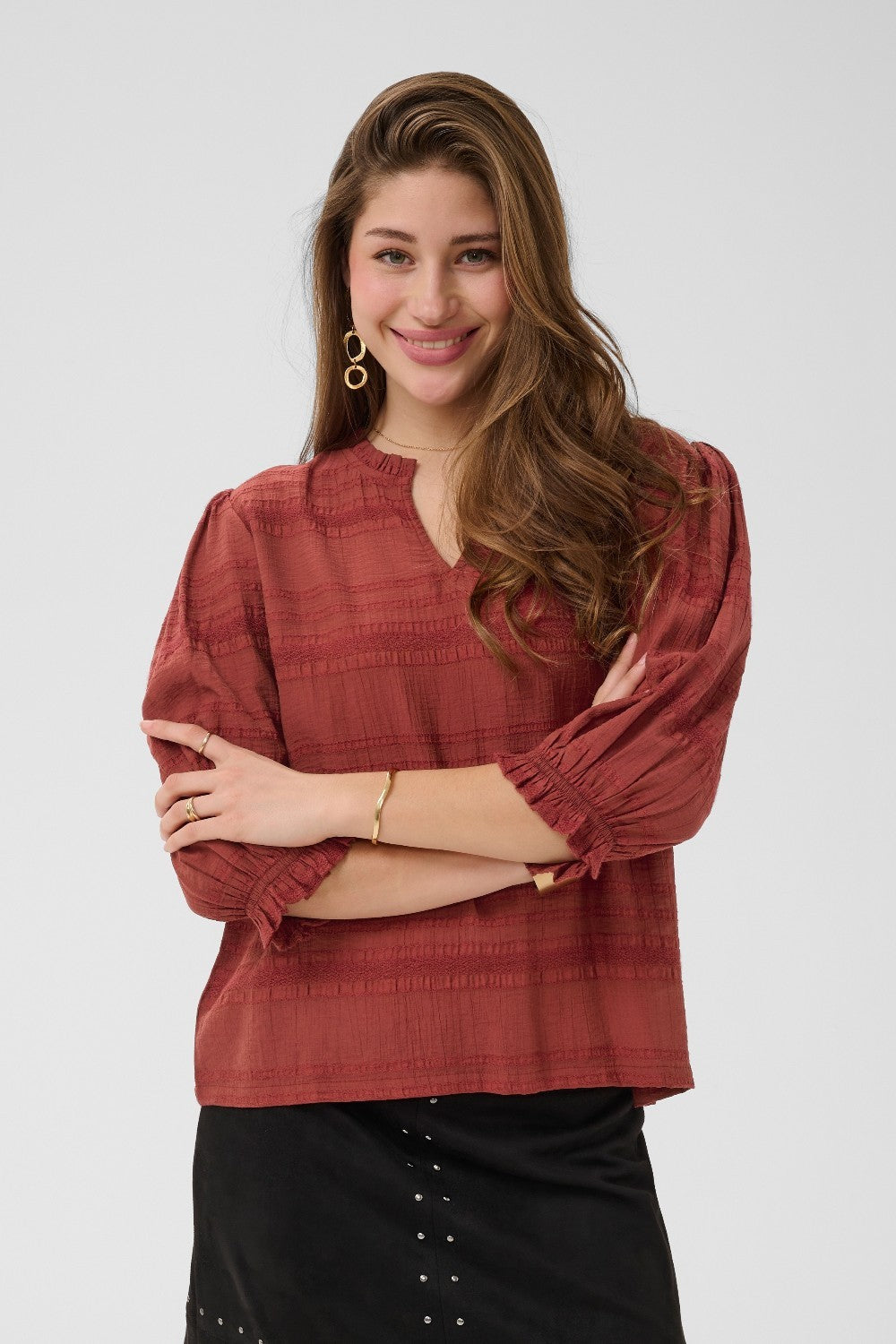 Woman wearing a red blouse with black pants on a white background
