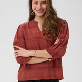 Woman wearing a red blouse with black pants on a white background