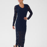 Woman wearing a navy blue dress with long sleeves on a white background