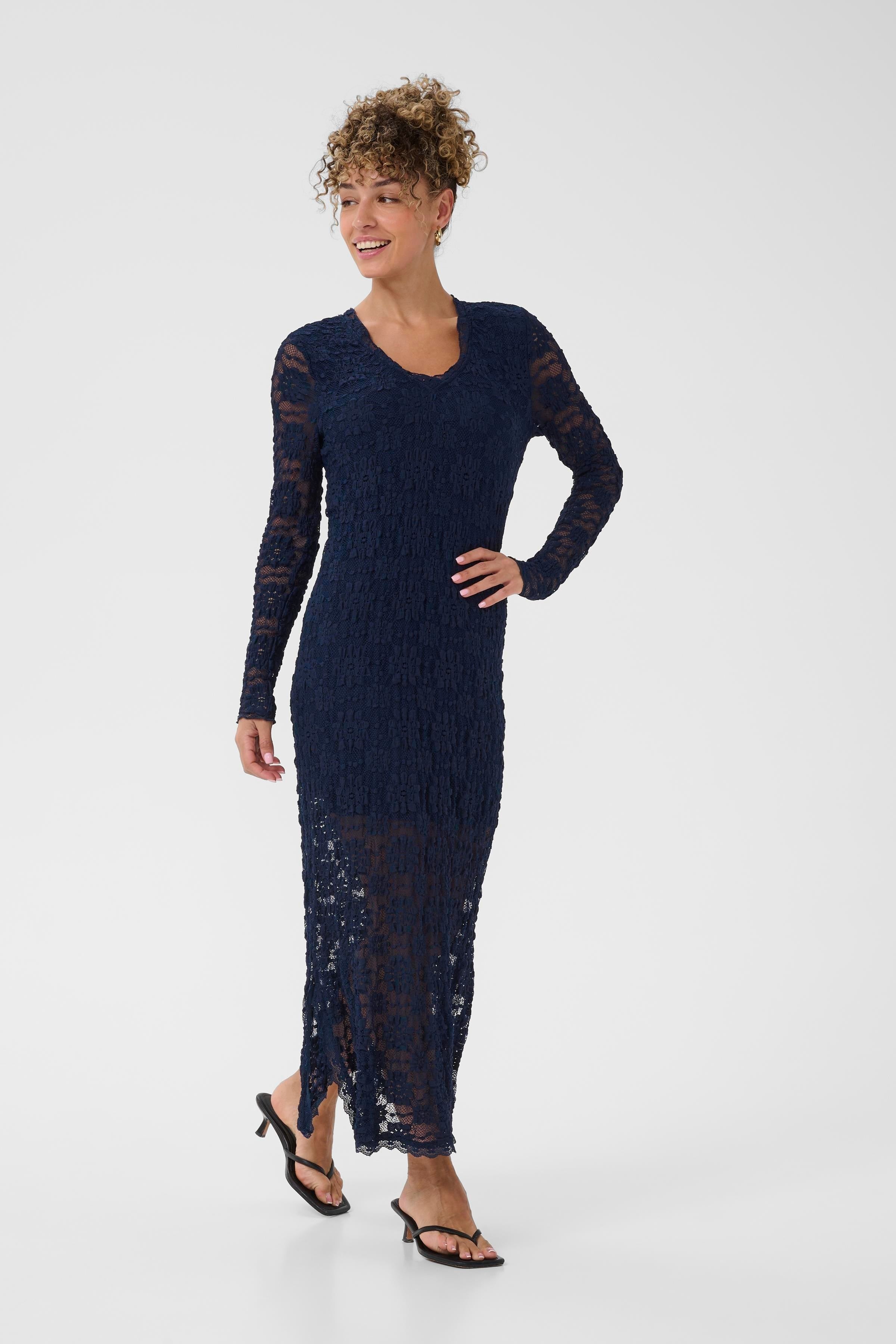 Woman wearing a navy blue dress with long sleeves on a white background