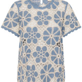 Crochet top with blue floral patterns on a white background