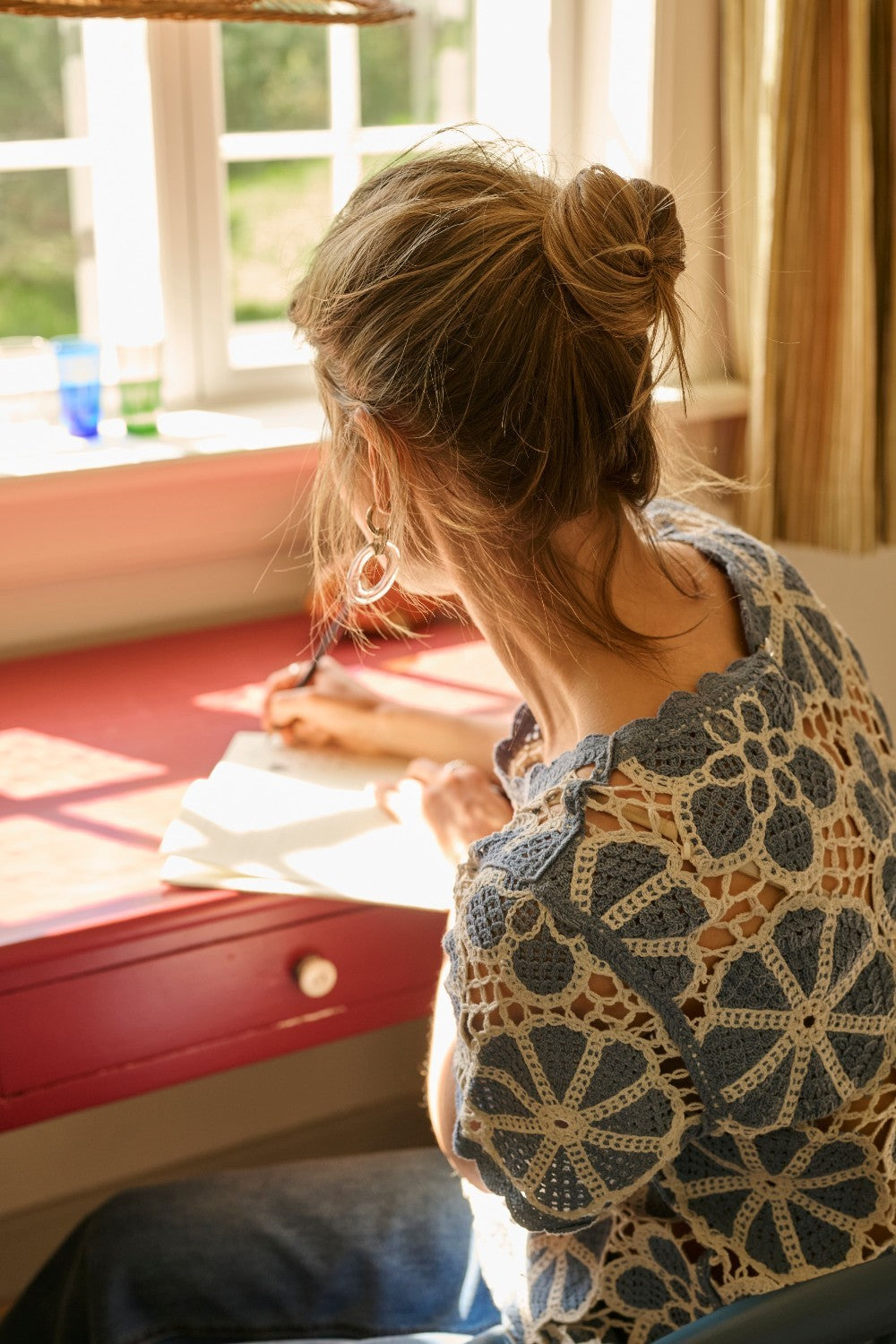 Woman sitting at a desk with a window in the background