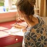 Woman sitting at a desk with a window in the background