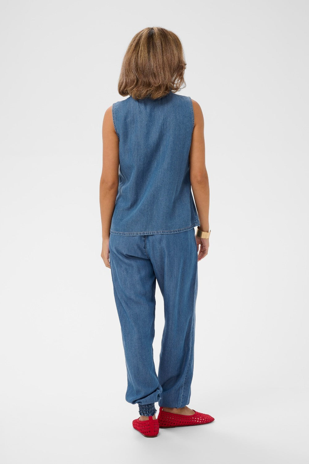 Person wearing a blue denim outfit on a white background