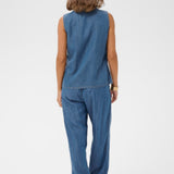Person wearing a blue denim outfit on a white background