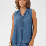 Woman wearing a sleeveless denim top and pants on a white background