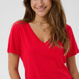 Woman wearing a red V-neck t-shirt against a plain background