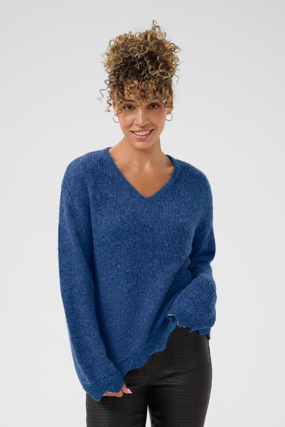 Woman wearing a blue sweater against a plain background