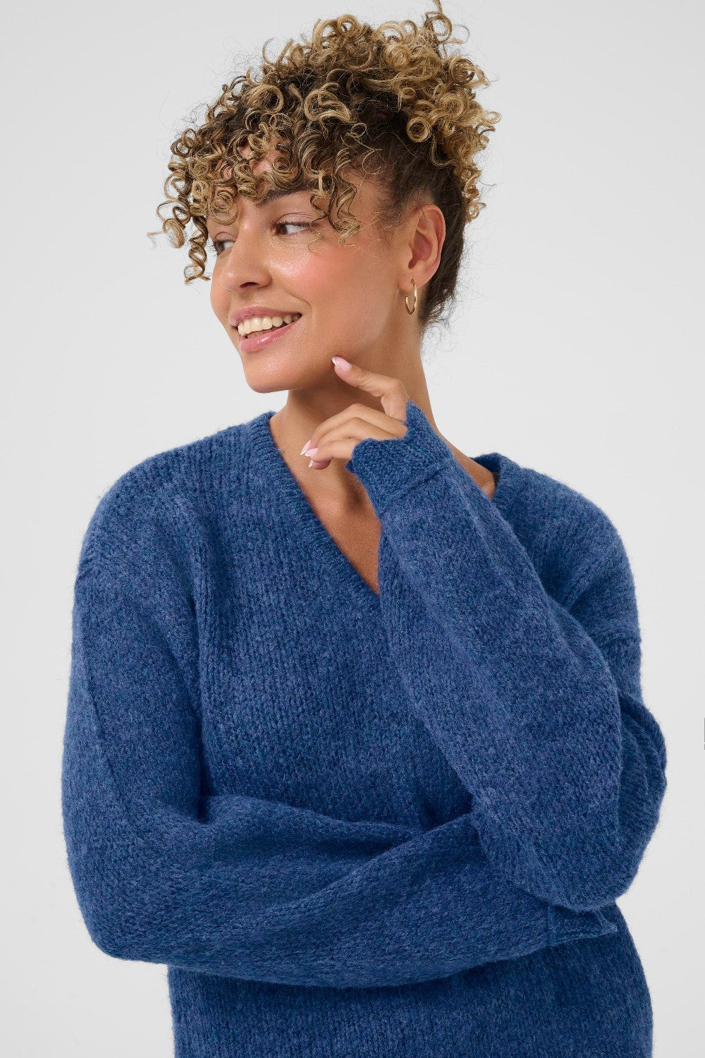 Woman wearing a blue sweater against a white background