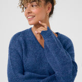 Woman wearing a blue sweater against a white background