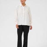 Person wearing a white shirt and black pants on a white background