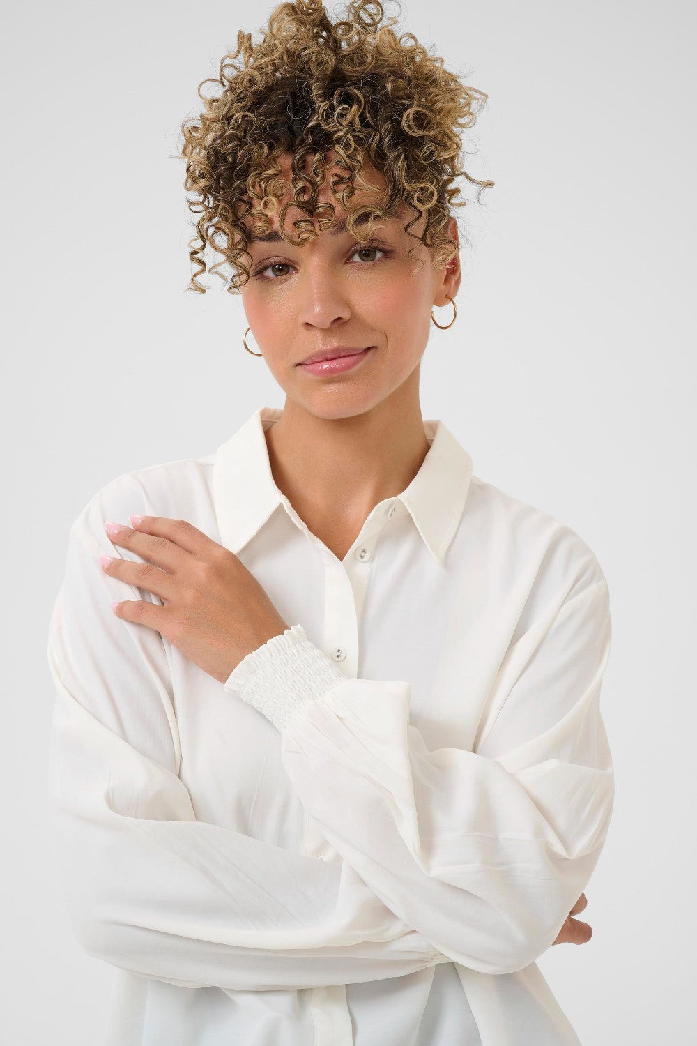 Woman wearing a white shirt against a plain background