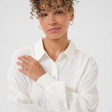 Woman wearing a white shirt against a plain background