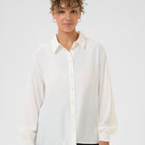 Woman wearing a white blouse against a plain background
