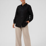 Person wearing a black shirt and beige pants on a white background