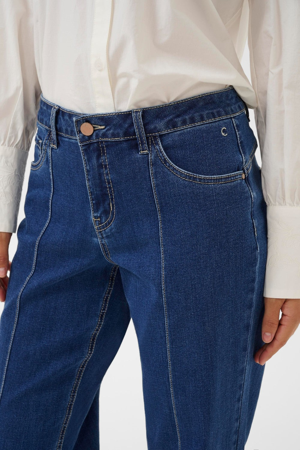Blue jeans worn by a person on a white background