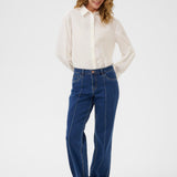 Woman wearing a white shirt and blue jeans on a white background