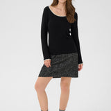 Woman wearing a black sweater and gray skirt on a white background