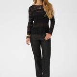Woman wearing a black top and black pants on a white background