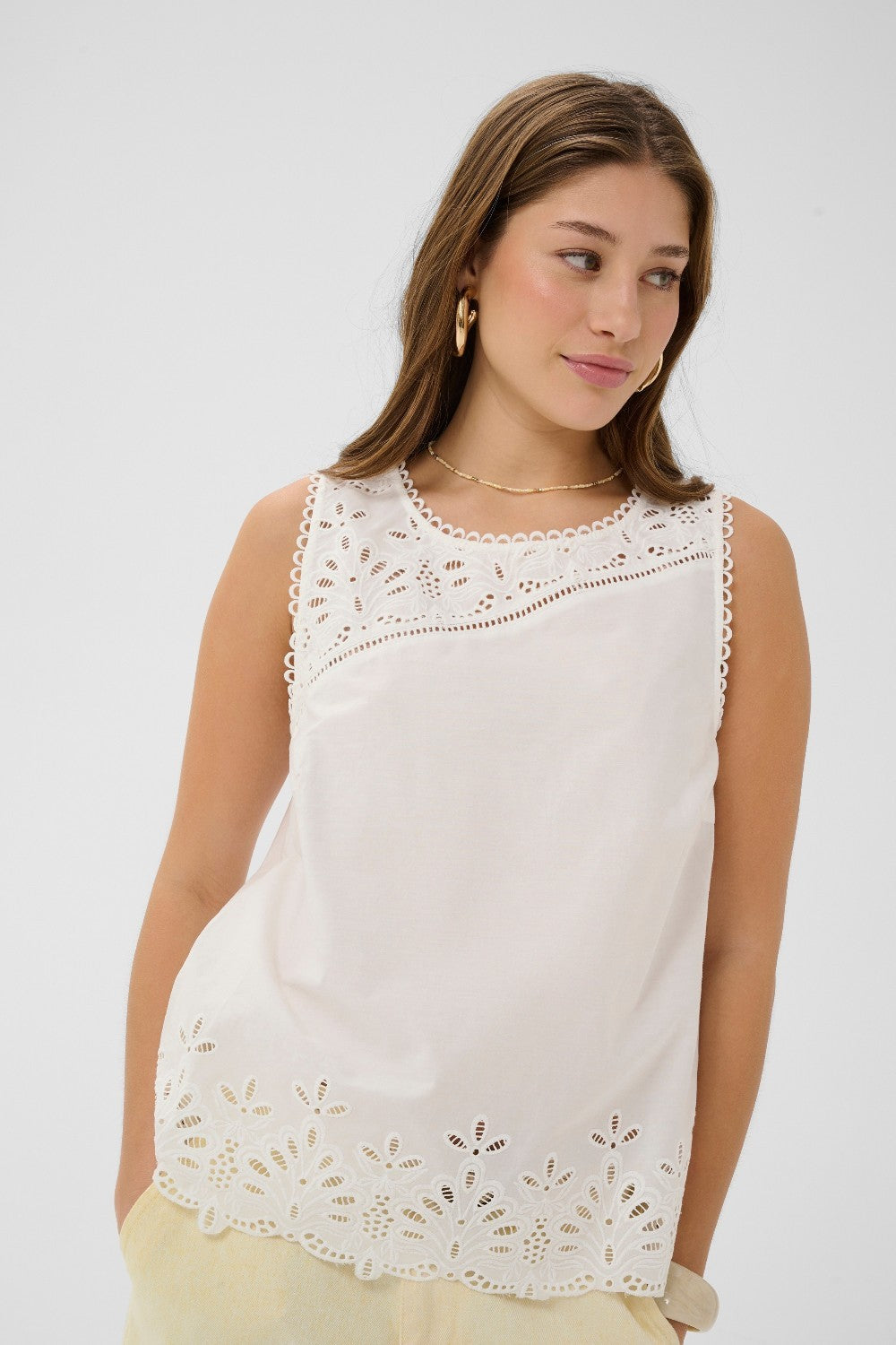 Made from 100% cotton, this top features delicate eyelet detailing that adds a touch of feminine charm to any outfit. 