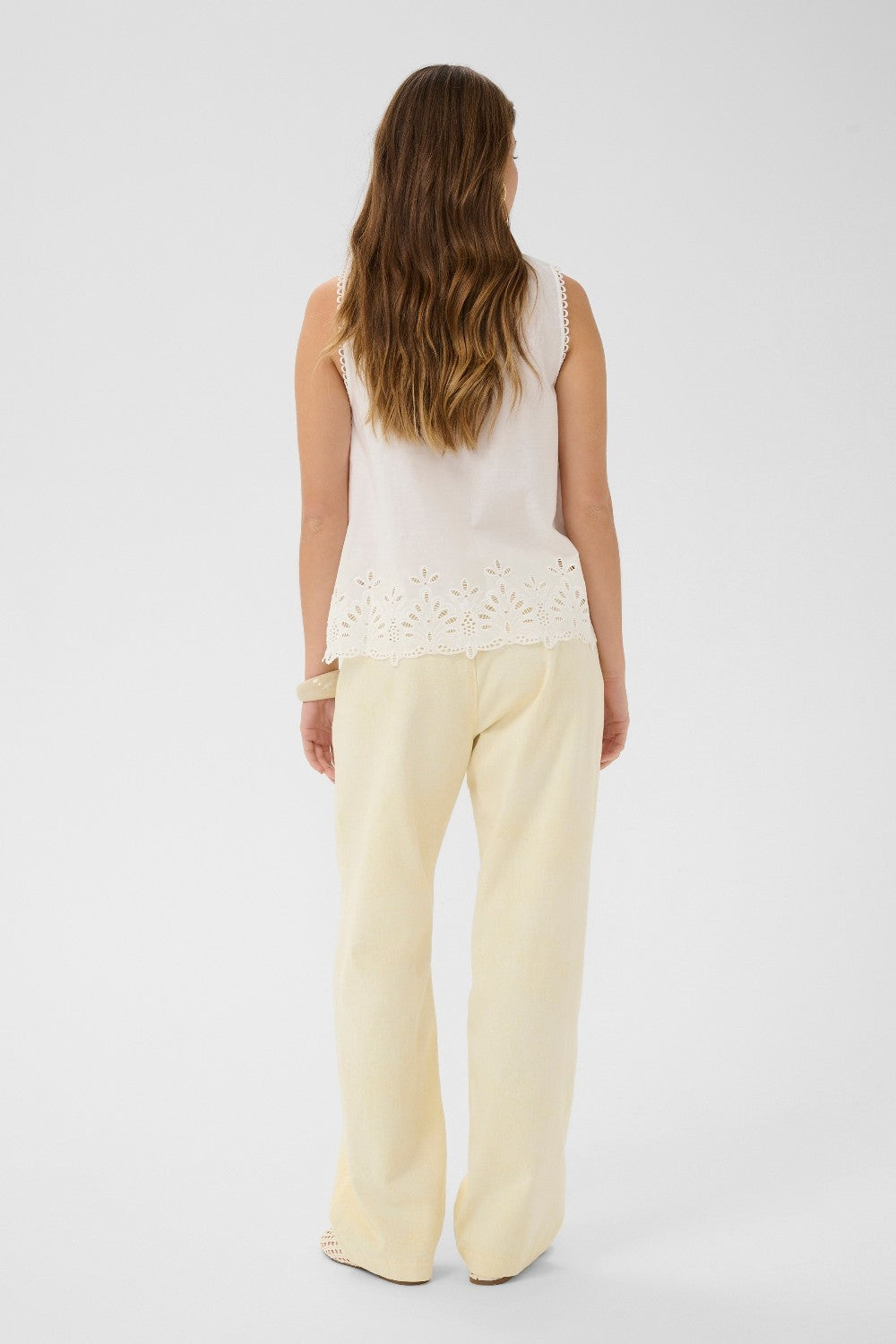 Made from 100% cotton, this top features delicate eyelet detailing that adds a touch of feminine charm to any outfit. 