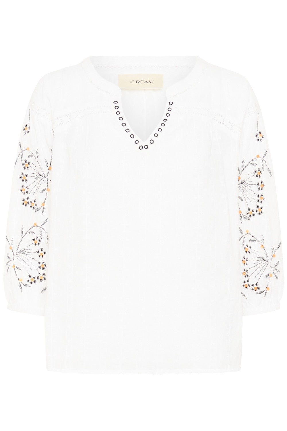 White top with floral embroidery on a white background
