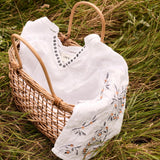 Wicker basket with white clothes on a grassy background