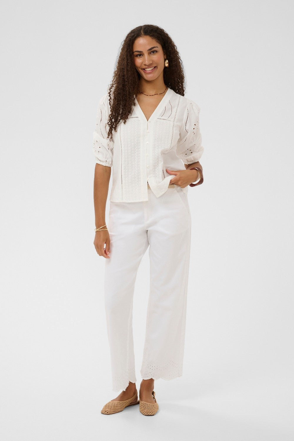 Woman wearing a white outfit with a plain background