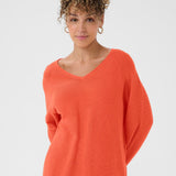 Woman wearing an orange sweater on a white background