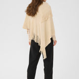 Woman wearing a beige fringe poncho on a white background