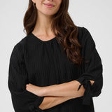 Woman wearing a black blouse against a white background