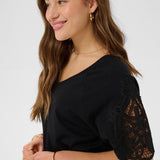 Woman wearing a black top with lace sleeves on a white background